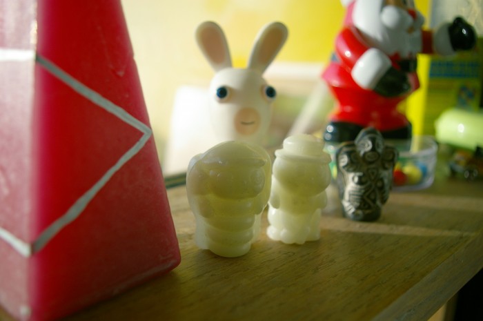 Image illustrant l'article. Photo d'une étagère avec une bougie rose, des figurines phosphorescentes en forme de papillon et insecte mignons, un lapin crétin, une figurine sud-américaine. Un père-noël distributeur de bonbons en arrière-plan.